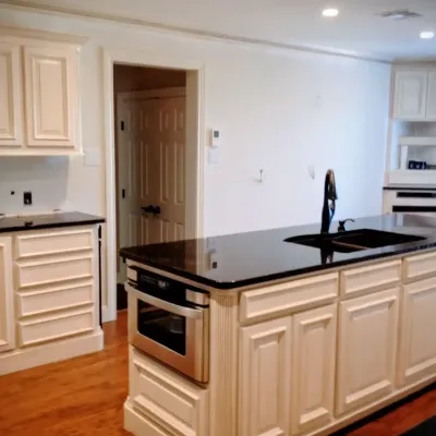 Cream kitchen cabinets with black countertops and custom island in Little Rock